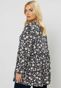Marinebluse mit floralen Mustern in Creme- und Rosttönen, featuring ein schichtedesign und langen Ärmeln. Weicher Stoff mit lockerer Passform.