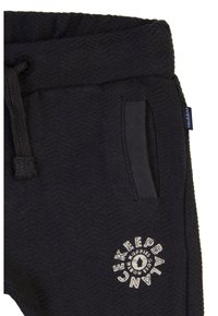 Zwarte gebreide joggingsbroek met een visgraatpatroon, voorzien van een trekkoord in de taille, een pocket en een rond logo in het wit aan de voorkant.