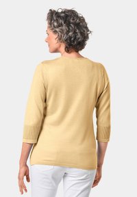 Geel gebreid sweater met driekwartmouwen, met ribgebreide accenten bij de manchetten. Gladde textuur, lichte scoop hals, casual pasvorm.