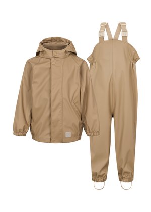 Veste beige imperméable avec une capuche ; équipée de fermetures à pression et de poignets élastiques, associée à des salopettes assorties avec des bretelles réglables et des chevilles élastiques.