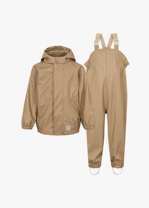 Μπεζ αδιάβροχο μπουφάν με κουκούλα; διαθέτει κουμπώματα snap και ελαστικούς καρπούς, συνδυασμένο με αντίστοιχες σακούλες με ρυθμιζόμενες τιράντες και ελαστικές γάμπες.