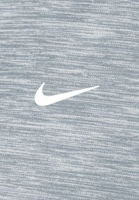 Tela atlética gris con un sutil patrón jaspeado. Presenta un destacado logo de swoosh de Nike en blanco en el centro.
