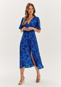 Modré květinové midi šaty s výstřihem do V, krátkými volánovými rukávy a předním rozparkem; lehký materiál s hladkým povrchem a živým vzorem.