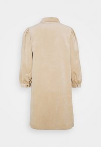Manteau beige à manches longues avec col, épaules bouffantes et poignets boutonnés, présenté de dos sur fond blanc.