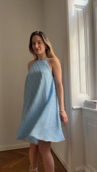 Helles blaues Halsbandkleid mit strukturierten vertikalen Linien, A-Linien-Form und mittellanger Länge bis zur Oberschenkelmitte, ausgestattet mit einem fließenden Rock, der schwingt.