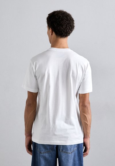 White cotton T-shirt with short sleeves, crew neckline, plain design, and straight cut. Worn with blue denim jeans, showcasing a casual fit.