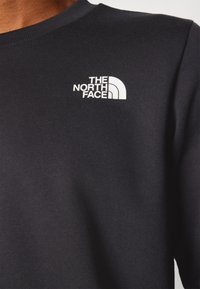 Sudadera negra de mezcla de algodón, con cuello redondo y puños acanalados. El logotipo blanco está destacado en el pecho.