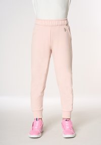 Pantaloni della tuta rosa con una fascia elastica in vita e tasche laterali, caratterizzati da un discreto dettaglio logo. Tessuto morbido con vestibilità affusolata.