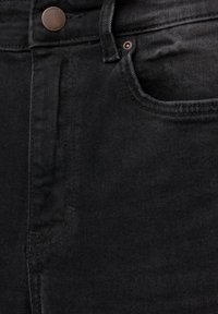 Schwarze Jeans aus Denim verfügen über ein klassisches Fünf-Taschen-Design, einen Metallknopfverschluss und einen weichen, strukturierten Stoff mit dezentem Verblassen.