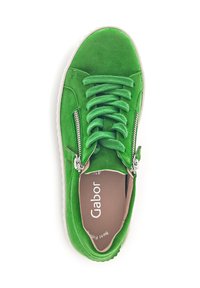 Grüne Wildlederschuhe mit runder Schuhspitze, flachen Schnürsenkeln und seitlichen Reißverschlüssen. Weiße Gummisohle und weiche Innenauskleidung. Markenlogo ist innen sichtbar.
