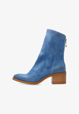 Niebieski zamszowy botek na kostkę z brązowym, drewnianym słupkowym obcasem i zamkiem błyskawicznym z tyłu, widoczny od zewnętrznej strony.