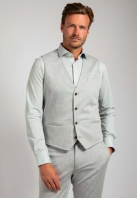 Hellgrau maßgeschneiderte Weste mit einem strukturierten Muster, fünf braunen Knöpfen und zwei vorderen Taschen, kombiniert mit einem passenden Hemd und einer Hose.