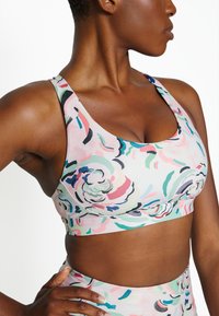 Sutiã desportivo com um padrão floral em rosa, verde e preto. Feito de um tecido suave, com alças largas e um corte ajustado.