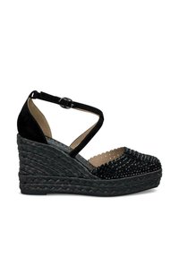 Sandali con tacco a pianta larga nera, con base intrecciata, texture decorata sulla punta e una cinghia alla caviglia nera con una fibbia metallica.