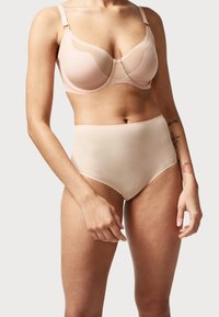 Light pink bra with transparent mesh panels and adjustable straps, paired with high-waisted nude seamless panties. Smooth fabric texture.