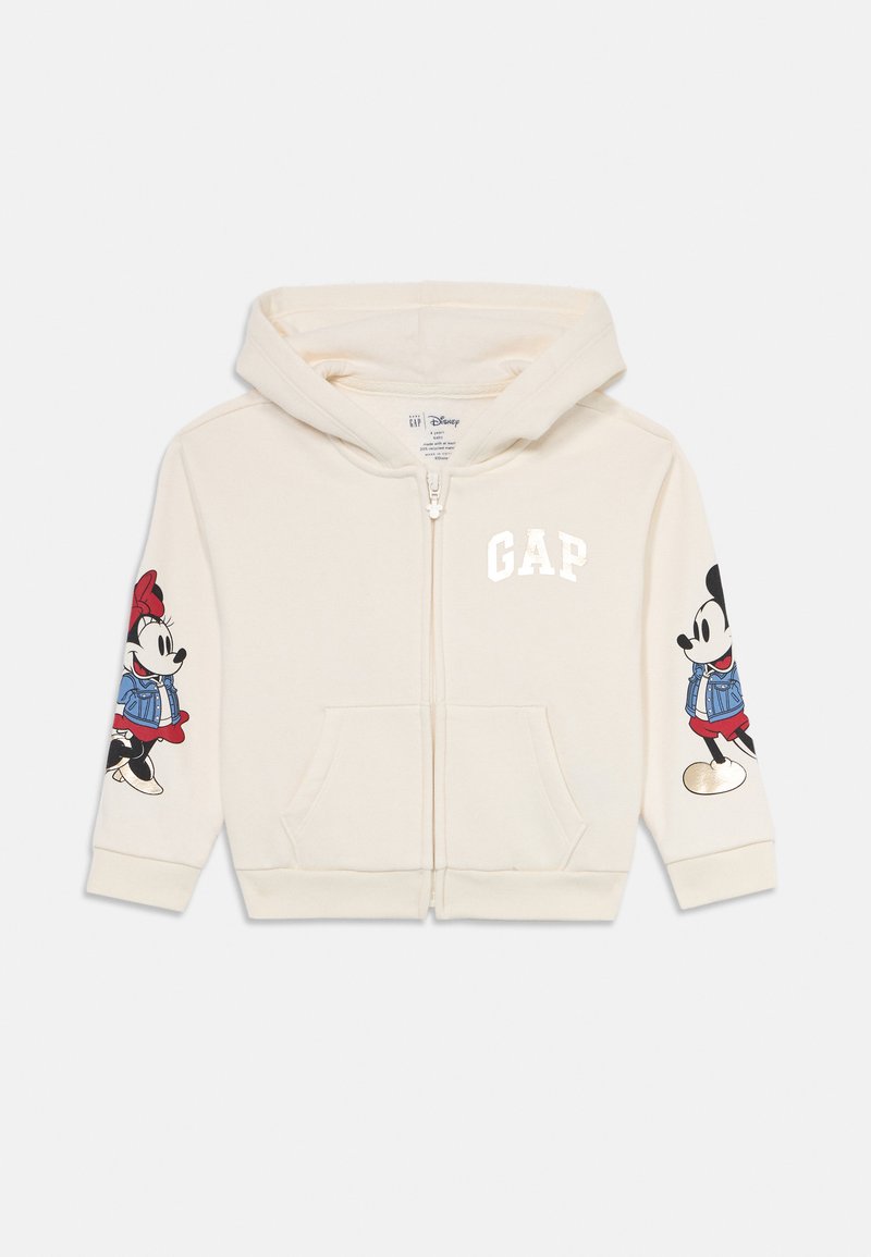 Sweatshirt crema com fecho éclair para crianças, capuz, bolsos frontais, logótipo GAP no peito e gráficos do Mickey e Minnie Mouse nas mangas.