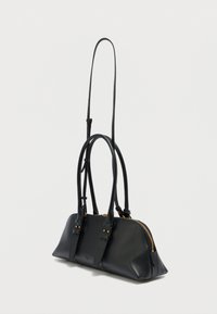 Μαύρη δερμάτινη τσάντα χειρός με φερμουάρ, δύο ρυθμιζόμενους ιμάντες και εξαρτήματα σε χρυσή απόχρωση. Ομαλή υφή και στρογγυλεμένο σχήμα με πλευρικές λεπτομέρειες.