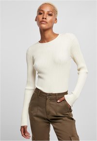 White ribbed long-sleeve top with a round neckline, paired with olive green cargo pants featuring pockets and a button closure.