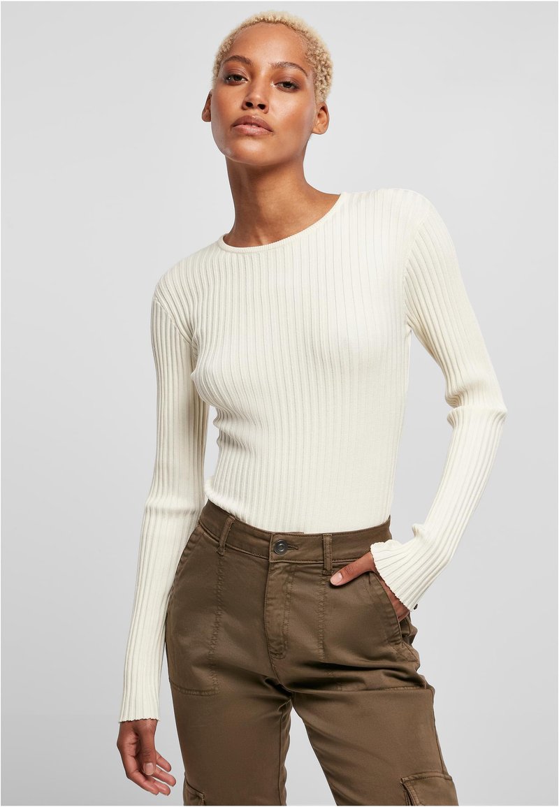 White ribbed long-sleeve top with a round neckline, paired with olive green cargo pants featuring pockets and a button closure.