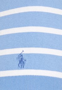 Ljusblå stickad tröja med vita horisontella ränder. Har en broderad logotyp av en ryttare i matchande blått. Mjuk textur.