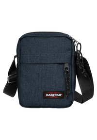 Sac bandoulière en tissu bleu foncé avec une bandoulière ajustable, poche avant zippée et patch logo Eastpak. Présente une forme rectangulaire et une surface texturée.