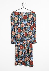 Blommig långärmad klänning med marinblå bakgrund och röda, blå och gröna blommor. Inkluderar en liten nyckelhålsdetalj bak.