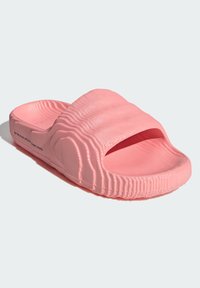 Rosa Slide-Sandale mit gerippter Textur, offener Spitze und leichter Krümmung. Hergestellt aus weichem Material, mit flacher Sohle und minimalistisches Design.