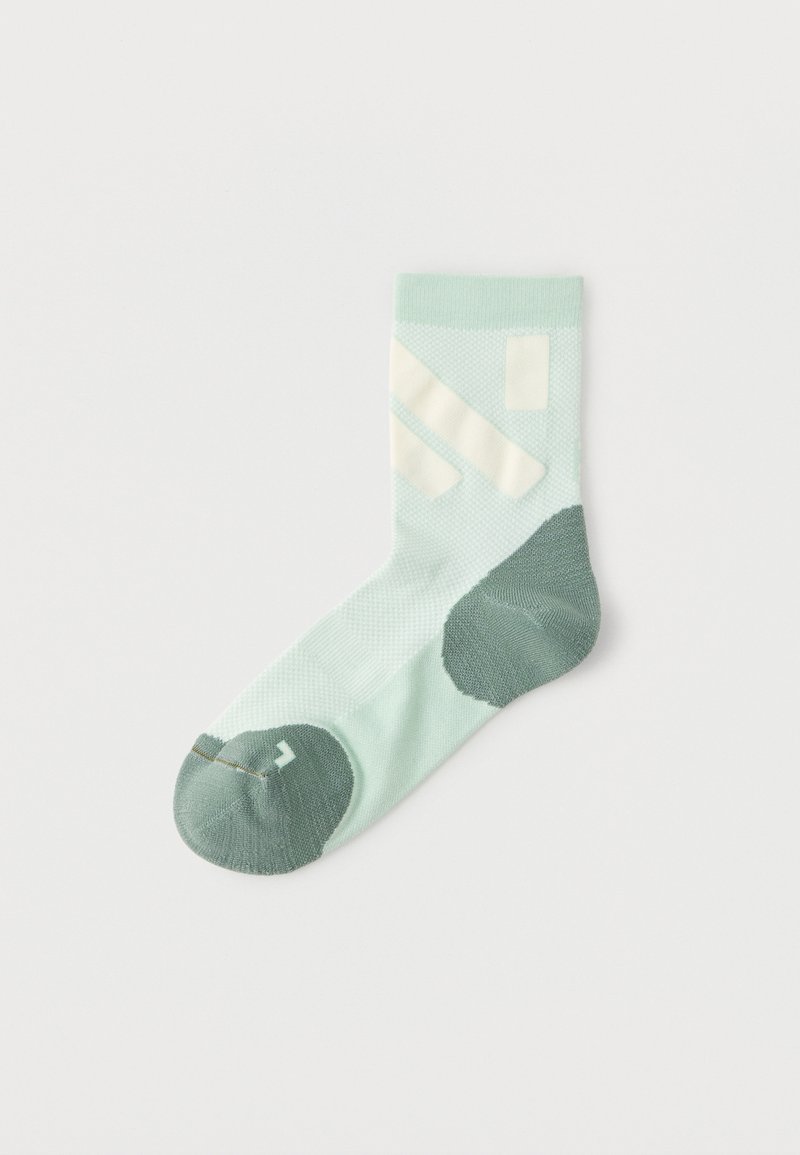 Single light green sock with dark green heel and toe, featuring white diagonal stripes and a small arrow on the toe area.