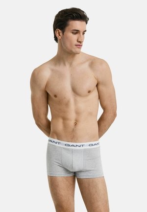 Graue Boxerbriefs mit enganliegendem Schnitt, ausgestattet mit einem weißen Bund, auf dem der Markenname "GANT" in marineblau zu sehen ist. Schlichtes Design, Material aus Baumwollmischung.