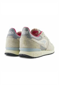Sneakers in suede beige con accenti grigi, pannelli in rete e foderato rosa. Presentano suola in gomma e "DYNA" stampato sul tallone.