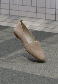 Beige korter king, valmistatud pehmest materjalist, omades teravat nina ja minimalistikku disaini. Sisaldab väikest kontsa ja silmust taga.