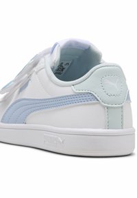 Białe sneakersy z jasnoniebieskimi akcentami, z teksturowaną cholewką, logo PUMA na pięcie oraz wyściółką w kołnierzu dla komfortu.