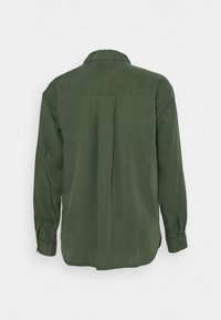 Grøn skjorte med lange ærmer lavet af glat stof, der har en klassisk krave, knapbesatte manchetter og en lige kant med en central søm på ryggen.