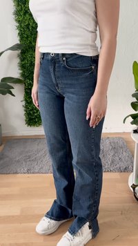 Jeans in denim blu scuro con vita alta e taglio dritto, caratterizzati da un classico design a cinque tasche e un lieve sfilacciamento all'orlo.