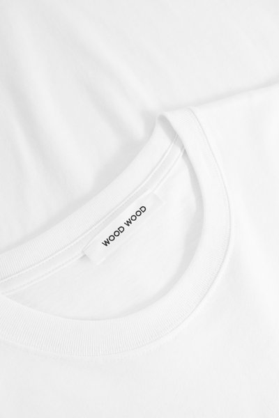 Balta kokvilnas T-kreklu ar apaļu kakla izgriezumu un ribotu apkakli. Uz apkakles ir lapele ar uzrakstu "WOOD WOOD", vienkārša tekstūra.