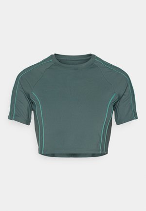 Crop-Top aus dunkelgrünem Stoff mit kurzen Ärmeln, kontrastierendem hellgrünem Nähen und einem runden Halsausschnitt in taillierter Passform.