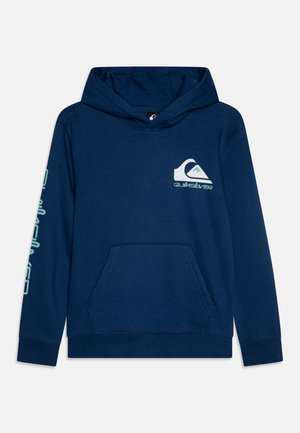 Navy blue hooded sweatshirt with front pocket, featuring a white and teal Quiksilver logo on the chest and text down one sleeve. Soft fabric.