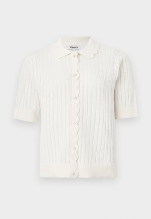 Cardigan blanc à manches courtes en tricot, col festonné et devant boutonné, avec une texture côtelée verticale et des manches retroussées.