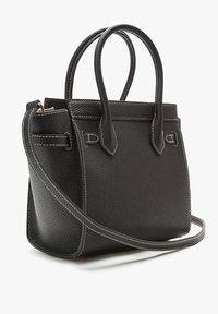 Czarna skórzana torebka o fakturze z ziarnami, z podwójnymi uchwytami u góry, odczepianym paskiem na ramię i białymi akcentami w stichu. Kompaktowy design.