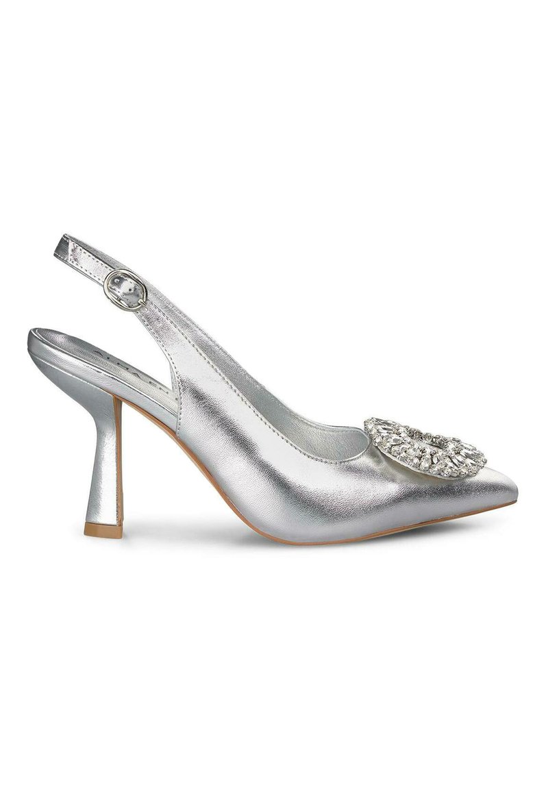 Escarpin argenté à talon haut, avec un bout pointu et un accent décoratif en strass sur le devant. Présente une finition métallisée texturée.