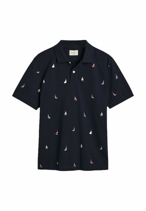 Navy poloshirt met korte mouwen, met witte en rode zeilboot borduursels over de gehele shirt. Klassieke kraag en knoopsluiting. Katoenen materiaal.