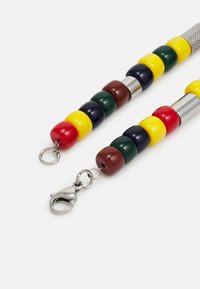 Sangle colorée en perles avec des perles rouges, jaunes, vertes et brunes ; dotée d'un fermoir métallique et d'un connecteur argenté texturé.