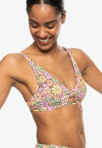 Bralet z cvetnim vzorcem, narejen iz mehkega in elastičnega materiala. Ima V-izrez, široke naramnice in nagubano obdelavo na sredi.