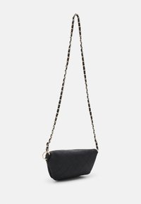 Bolso cruzado negro acolchado con una larga correa de cadena entrelazada con tela negra, aislado sobre un fondo blanco.