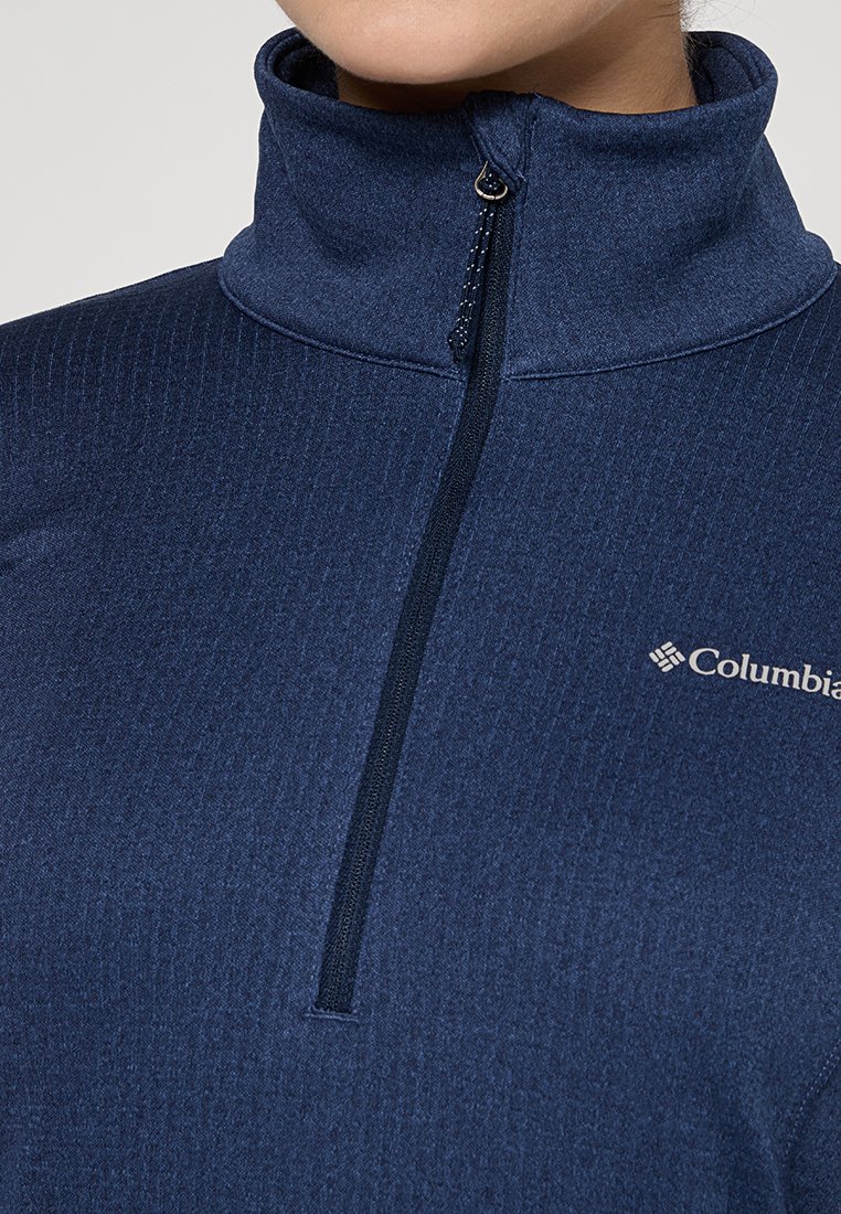 Maglione in felpa blu navy con mezzi zip, tessuto testurizzato, colletto alto e logo Columbia sul lato sinistro. La zip è verticale.