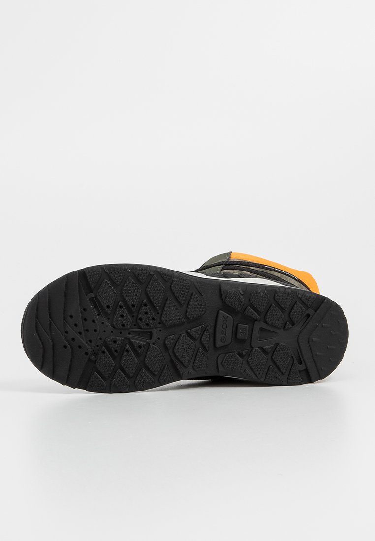 Schwarze Gummisohle mit texturiertem Grip-Muster, ausgestattet mit einem glatten, dunklen Obermaterial und leuchtend orangefarbenen Akzenten. Strapazierfähig und auf Bodenhaftung ausgelegt.
