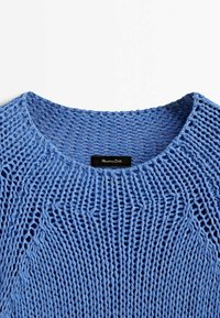 Niebieski sweter dziany o luźnym kroju, z szerokim dekoltem i fakturą otwartego splotu. Zawiera metkę marki wewnątrz kołnierza.