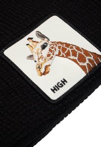 Patch nera lavorata a maglia con una giraffa ricamata, con motivi visibili sul collo e la parola "HIGH" sottostante su uno sfondo bianco.