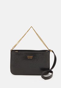 Zwarte synthetische handtas met een gestructureerd slangenpatroon, een gouden kettingriem en een geperst "GUESS EST 1981" logo aan de voorkant.