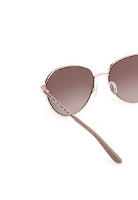 Gafas de sol de oro rosa con una forma angular y de gran tamaño, lentes marrones degradados y detalles texturizados en las varillas marrones. Cuenta con almohadillas nasales ajustables.